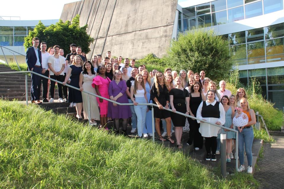 Gruppenbild der Absolventinnen und Absolventen auf einer Treppe