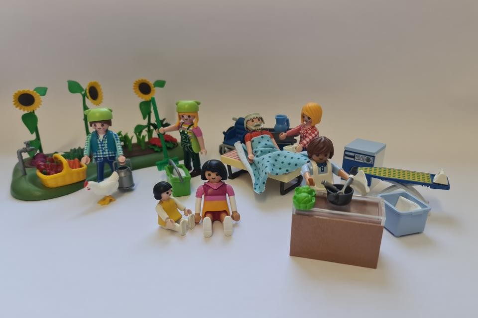 Mit Playmobil-Figuren sind die typischen Aufgaben von Dorfhelferinnen dargestellt.