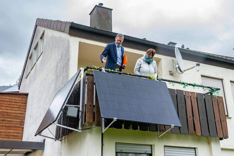 Zwei Personen stehen auf dem Balkon und betrachten ein Balkonkrafrwerk